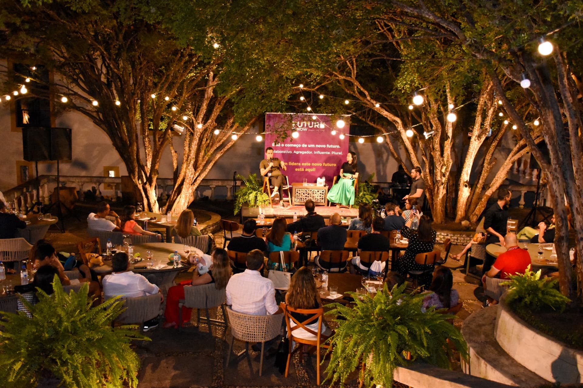 Palestra ao ar livre em jardim iluminado à noite
